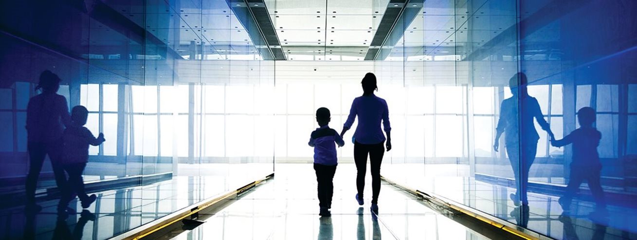 Woman and her son walking down a hallway
