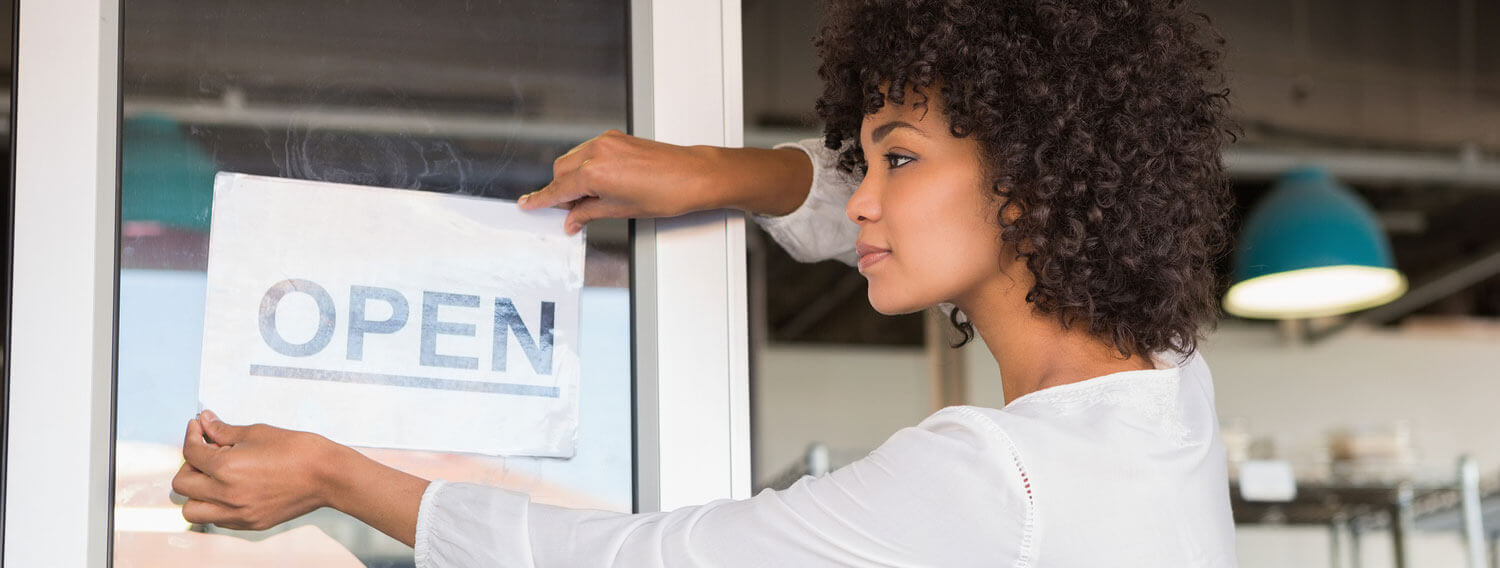 business owner putting up an open sign