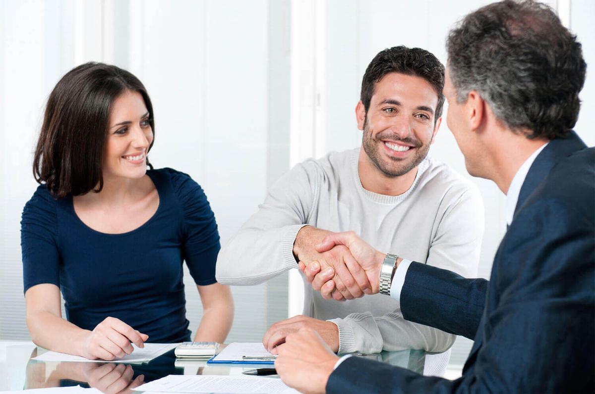 couple closing a deal with a business man