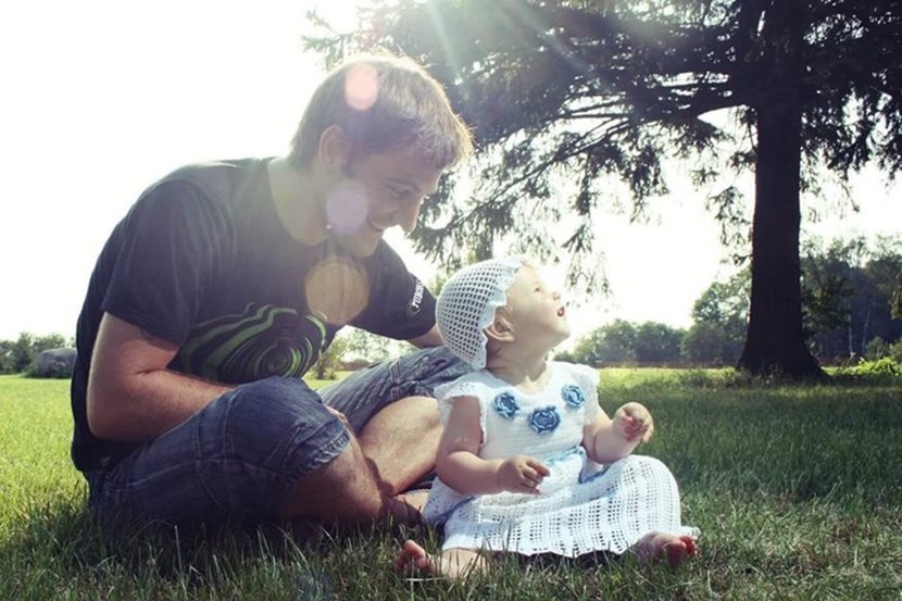 father and daughter sitting on the grass