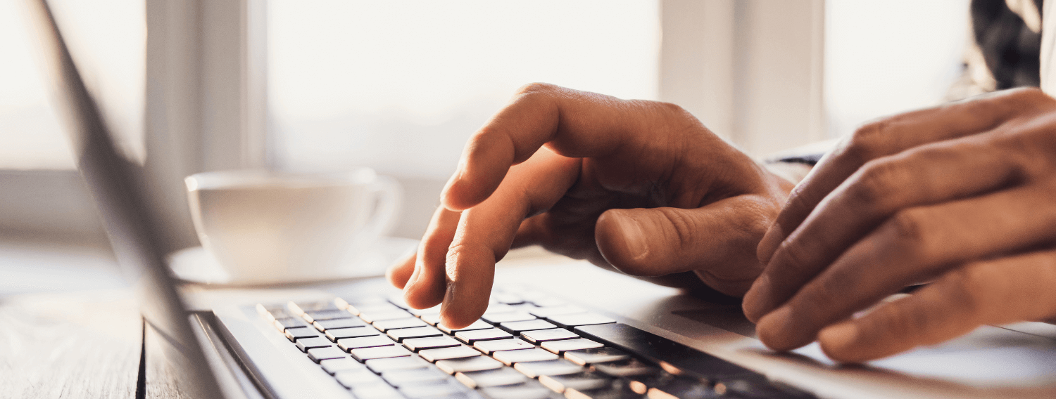 Close up image of hands typing on laptop