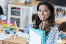 Woman holding notebooks in school setting