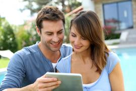 couple looking at tablet in yard