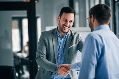 Happy business owner shaking employee's hand