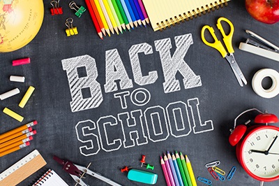 Back To School written on a chalkboard surrounded by school supplies