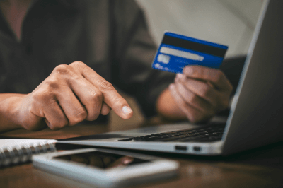 Man typing credit card information into a laptop