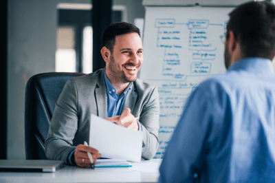 Employer talking with employee while at a desk
