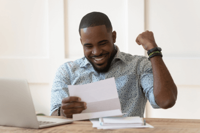 Man receiving good news in a letter and showing excitement