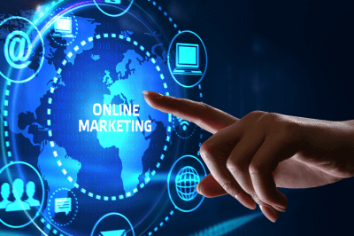 Womans finger pointing to the word Online Marketing with different marketing related icons floating around the word