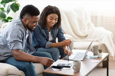 Couple with a laptop and calculator and a sheet of paper