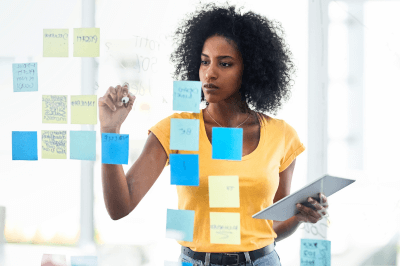 business owner writing her business plan on sticky notes