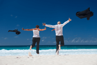 Senior couple running into retirement on beautiful beach