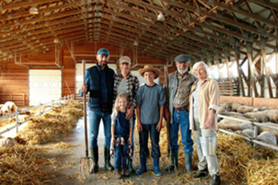 multi-generational family of farmers gathered in a barn
