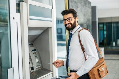 smiling man at an ATM