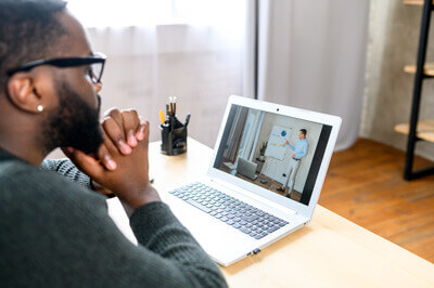 man watching an educational video on his laptop