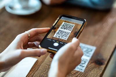 Person using their smart phone to scan a QR Code