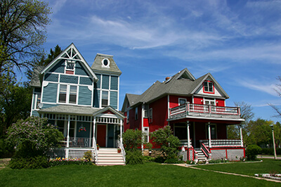 Two houses next to each other. A blue one on the left and a red one on the right.