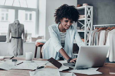 business owner of in her clothing shop looking at her laptop