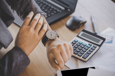 Business owner checking the watch on her wrist