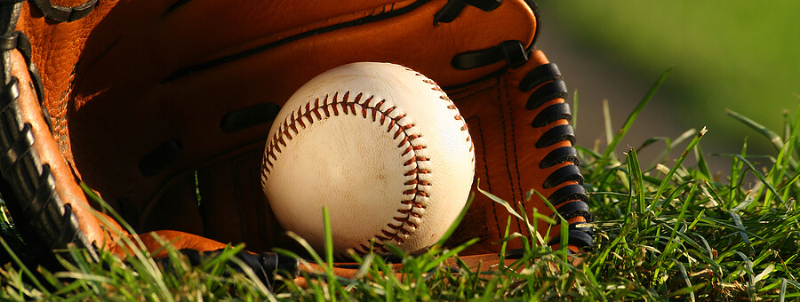 baseball in a catcher mitt on the grass
