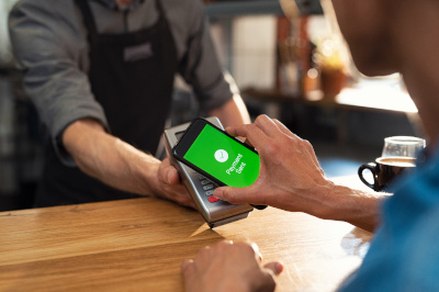 Person using their mobile wallet app to make a purchase in a coffee shop