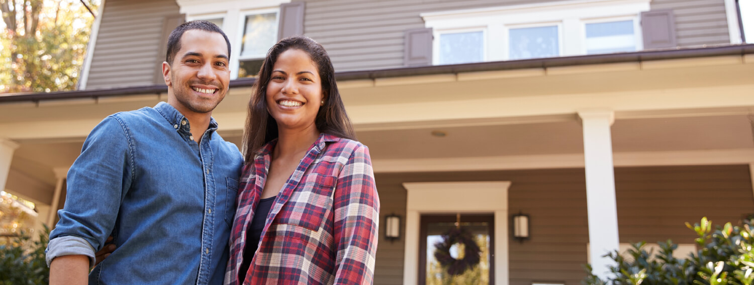 Couple standing outside of a house