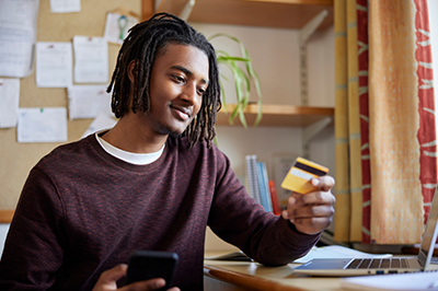 College student holding a credit card