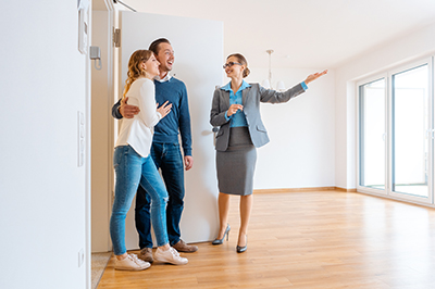 realtor showing home to young couple