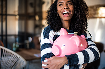 happy young woman hugging a piggy bank