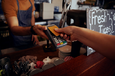 person paying for their coffee shop order with a contactless debit card