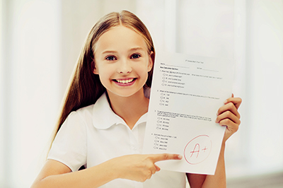 Image of a young girl holding a test with an A+
