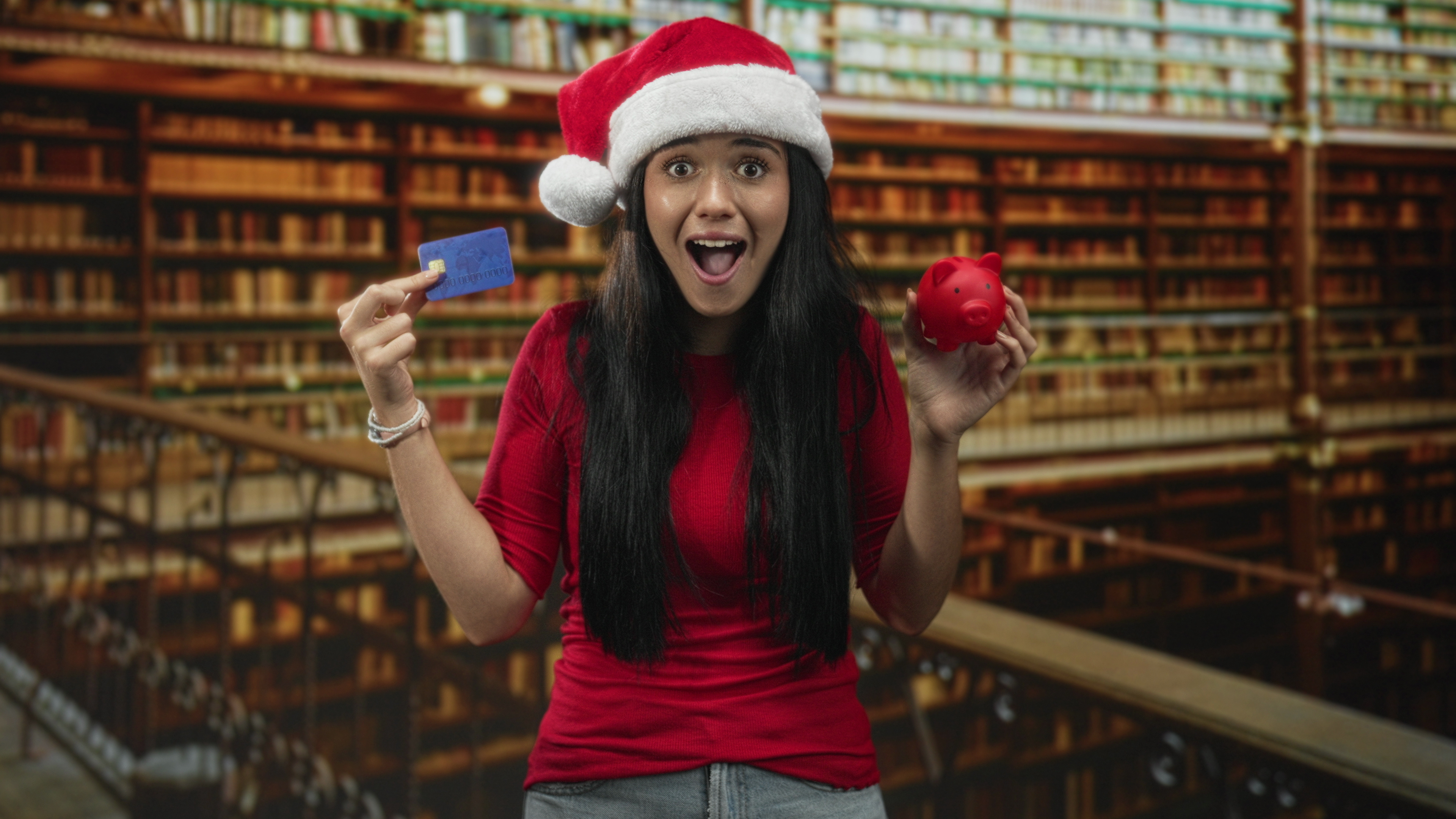 Woman standing with santa hat, ornament, and debit card