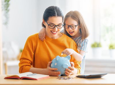 mother and daughter holding piggybank
