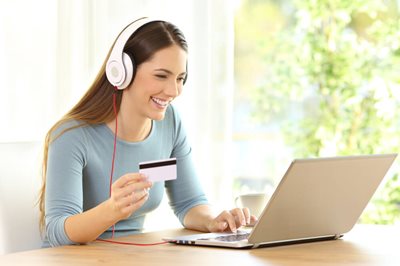 older teen girl on laptop with debit card in hand