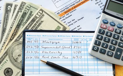checkbook open with calculator and cash