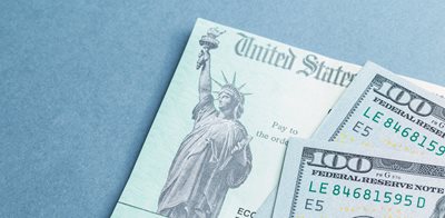two hundred dollar bills on top of a check from the United States Government