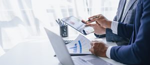 businessman looking at documents and tablet, doing finances